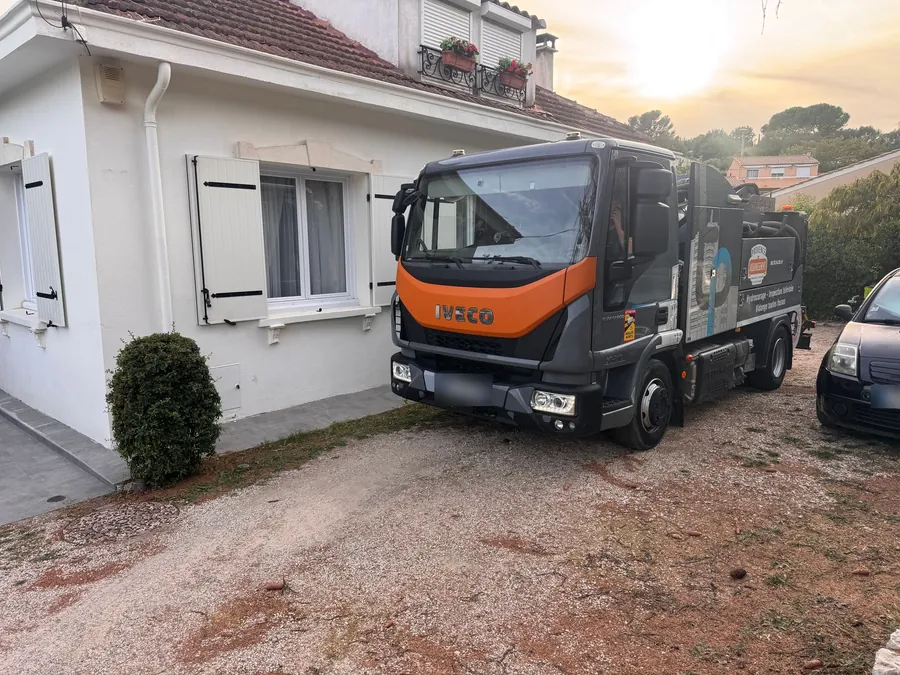Le camion de Provence Assainissement garé devant une maison, vu de face