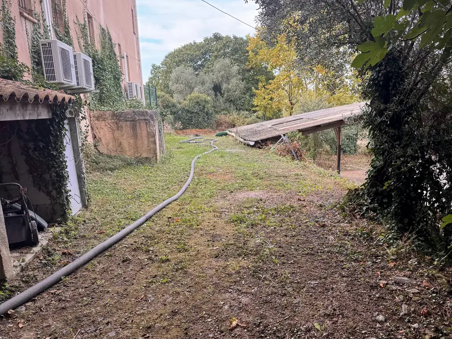 Le tuyau du camion déroulé dans l'herbe le long d'une maison